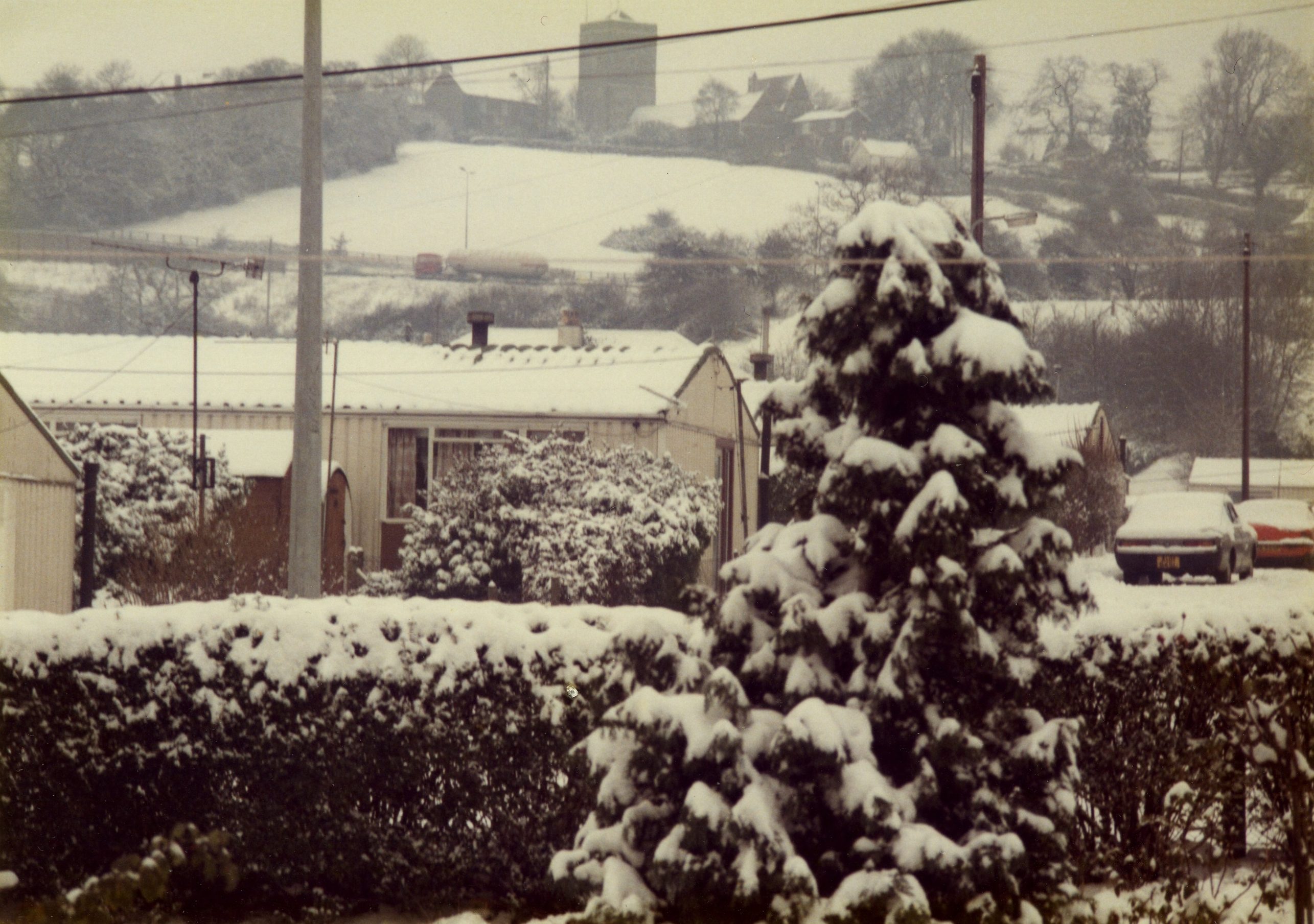 A prefab (Arcon Mk V) covered with snow, and tree, Newport, Wales