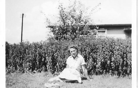 Mrs Clare sitting in the garden of her prefab