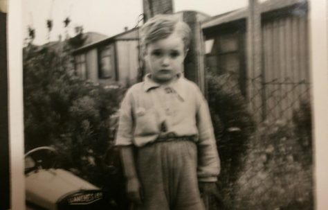 Small boy with toy car in front of Arcon prefab