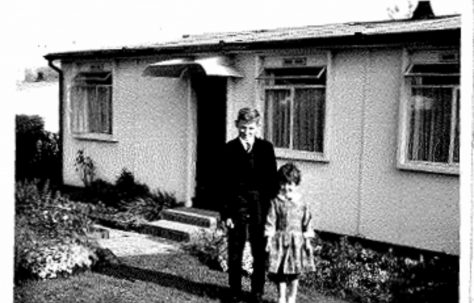 Photo of Allen and Judith Sawkins' family prefab (AIROH) in Farnham, Surrey, 50s, with brother and sister Allen and Judith in front of prefab