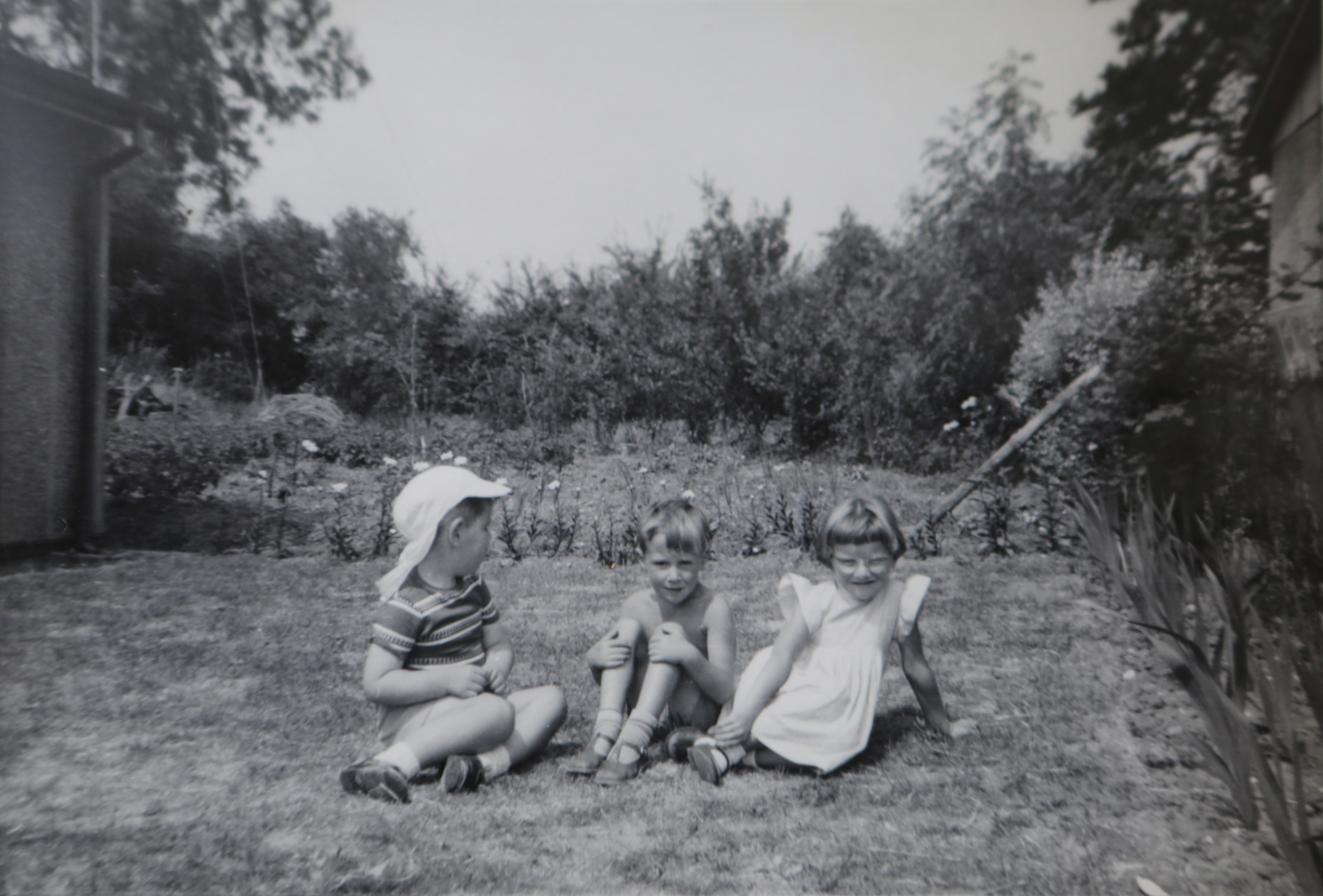 Three small children in the Kapitan prefab garden in Ipswich