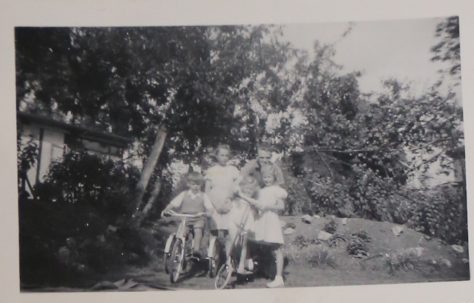 Four children, an adult and two bikes on the prefab estate at Willesden