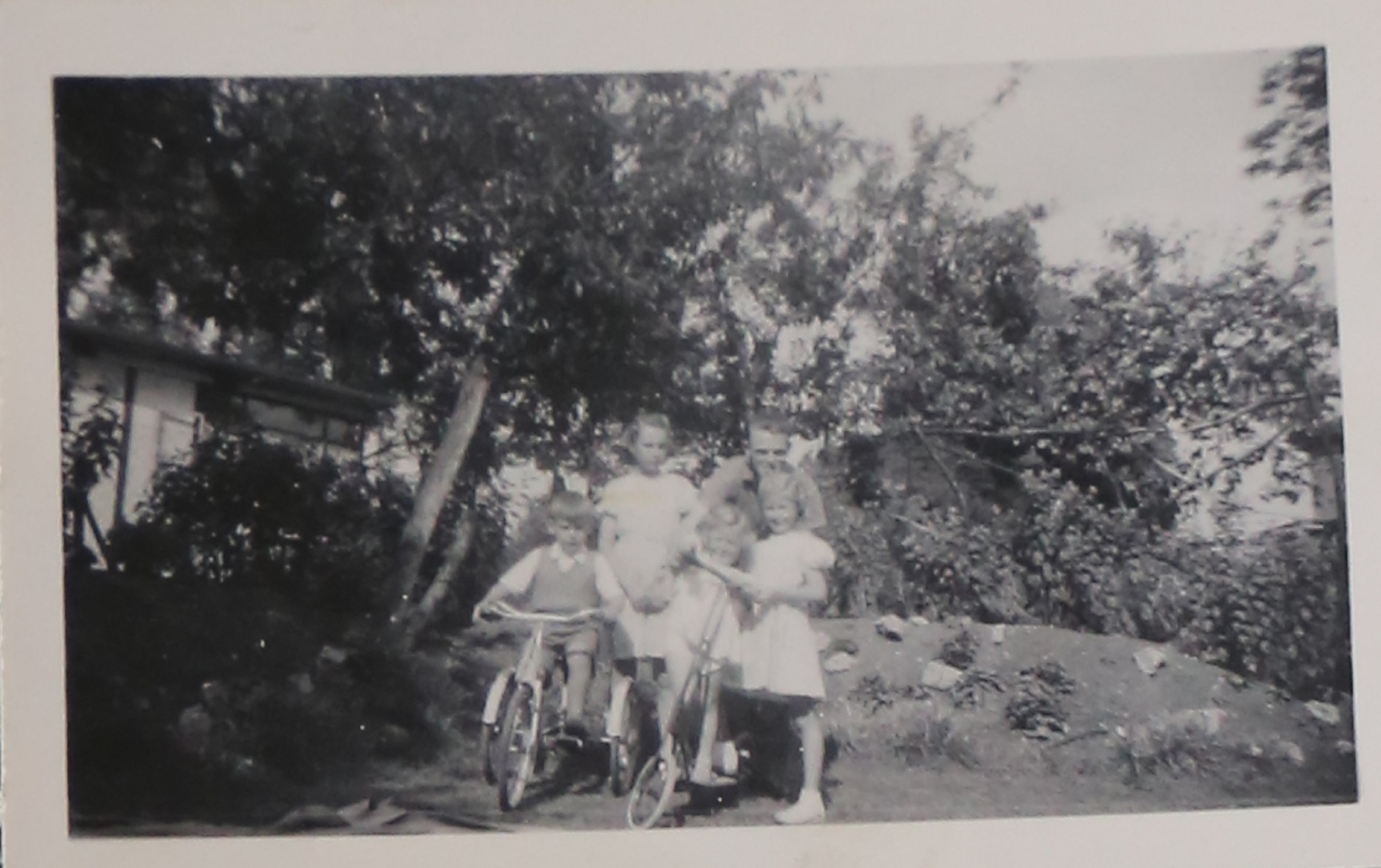 Four children, an adult and two bikes on the prefab estate at Willesden