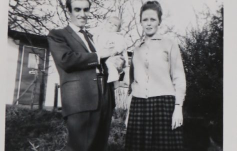 Penny Bishop as a baby with her mum and dad outside their prefab