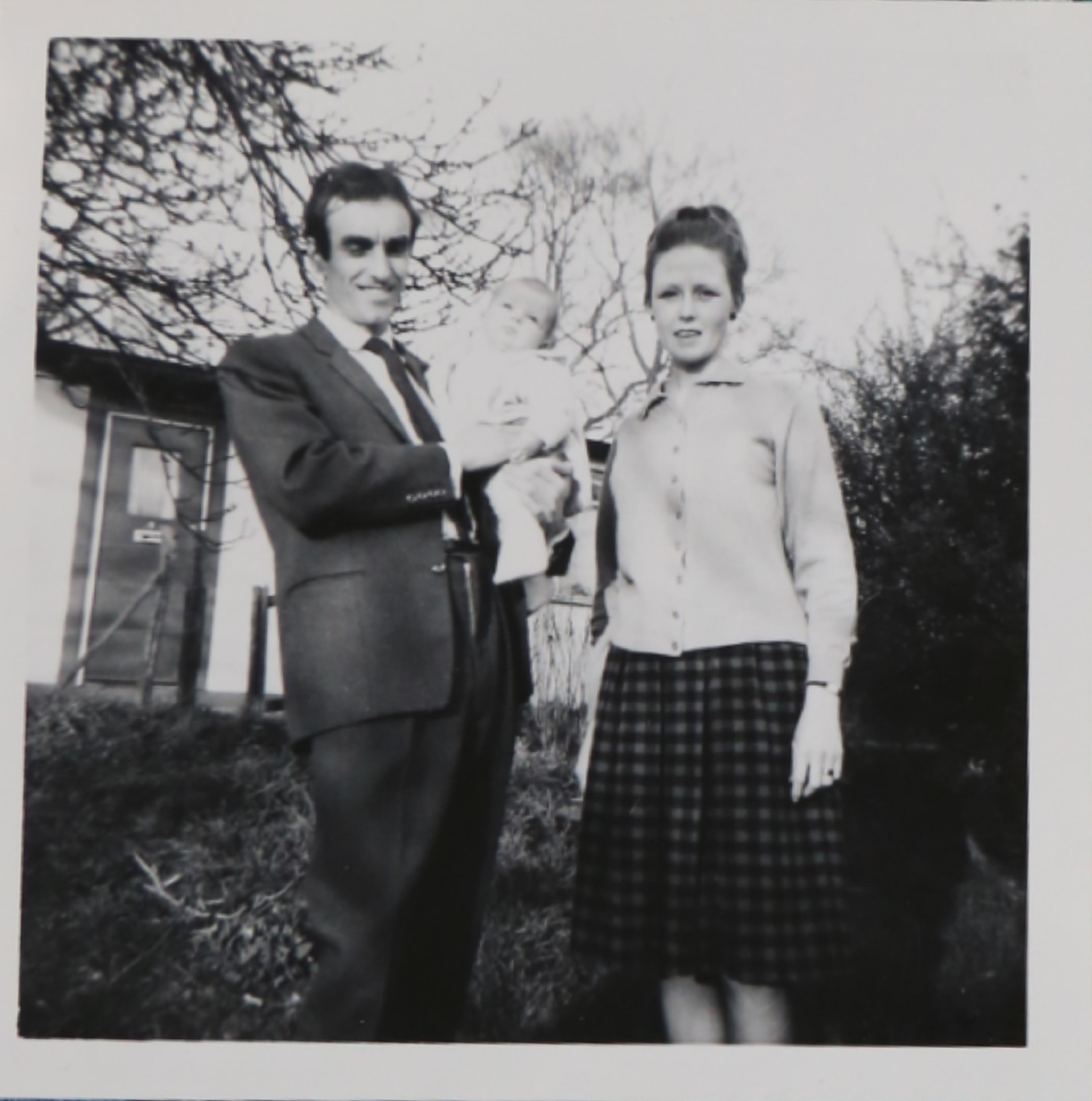 Penny Bishop as a baby with her mum and dad outside their prefab
