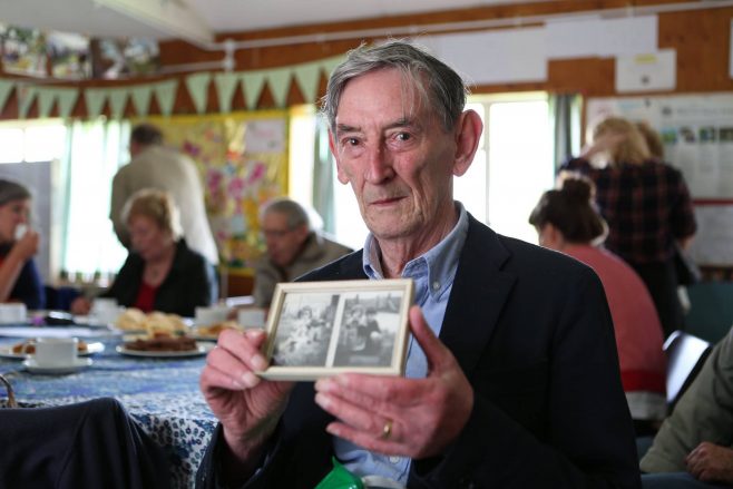 Ray Smith holding photos of his family prefab in Penarth, South Wales at the Excalibur at 70 event, 2016 | Prefab Museum