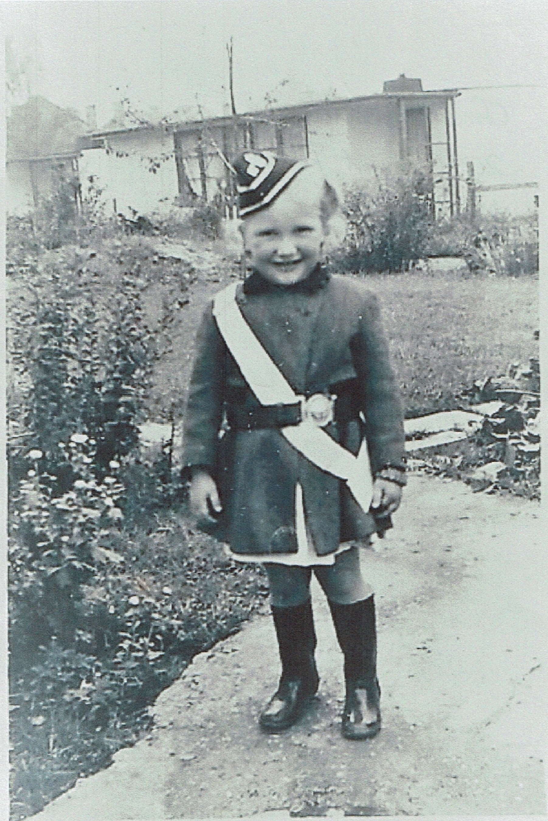 Small child in costume in prefab garden. Willesden