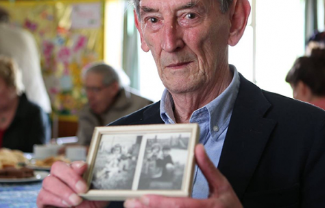 Ray Smith with photos of his prefab in Penarth
