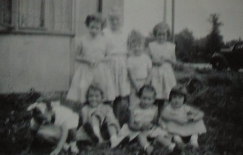 Group of eight children in front of Uni-Seco prefab, Silver End