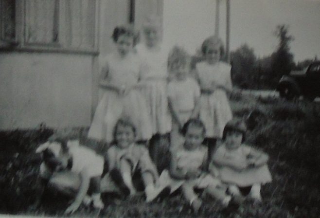 Group of eight children in front of Uni-Seco prefab, Silver End
