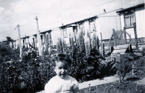 Little girl in front of prefabs on the Harold Hill estate