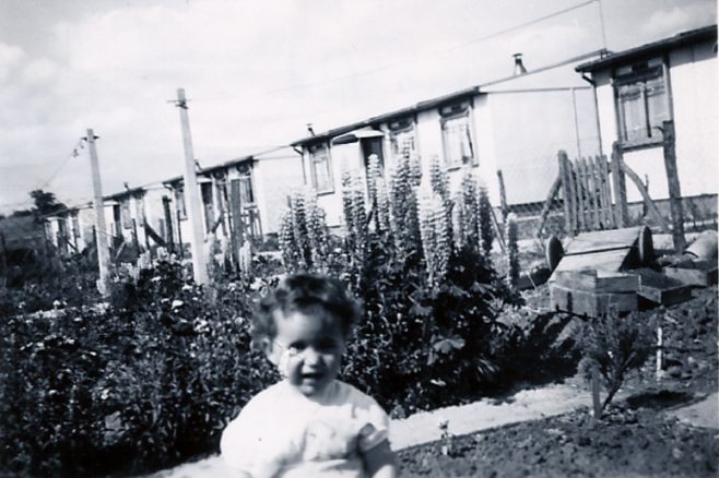 Little girl in front of prefabs on the Harold Hill estate
