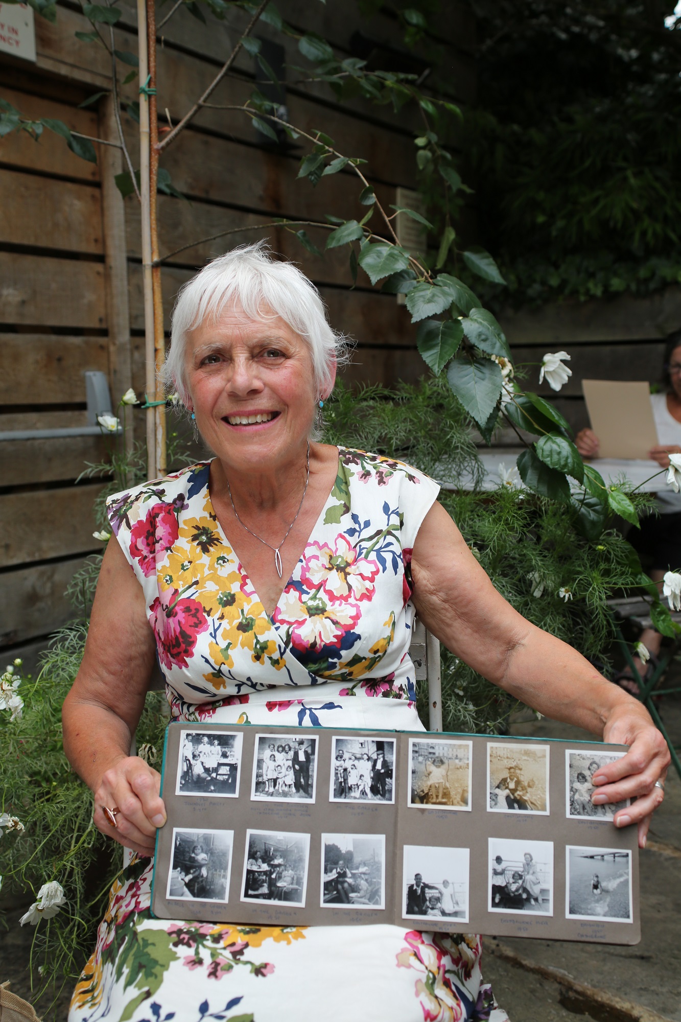 Portrait of Catherine Bazell holding a photograph album