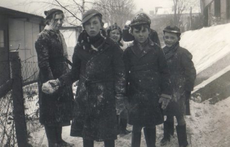 A group outside the prefabs in the snow, Dartmouth Park Hill, London N19