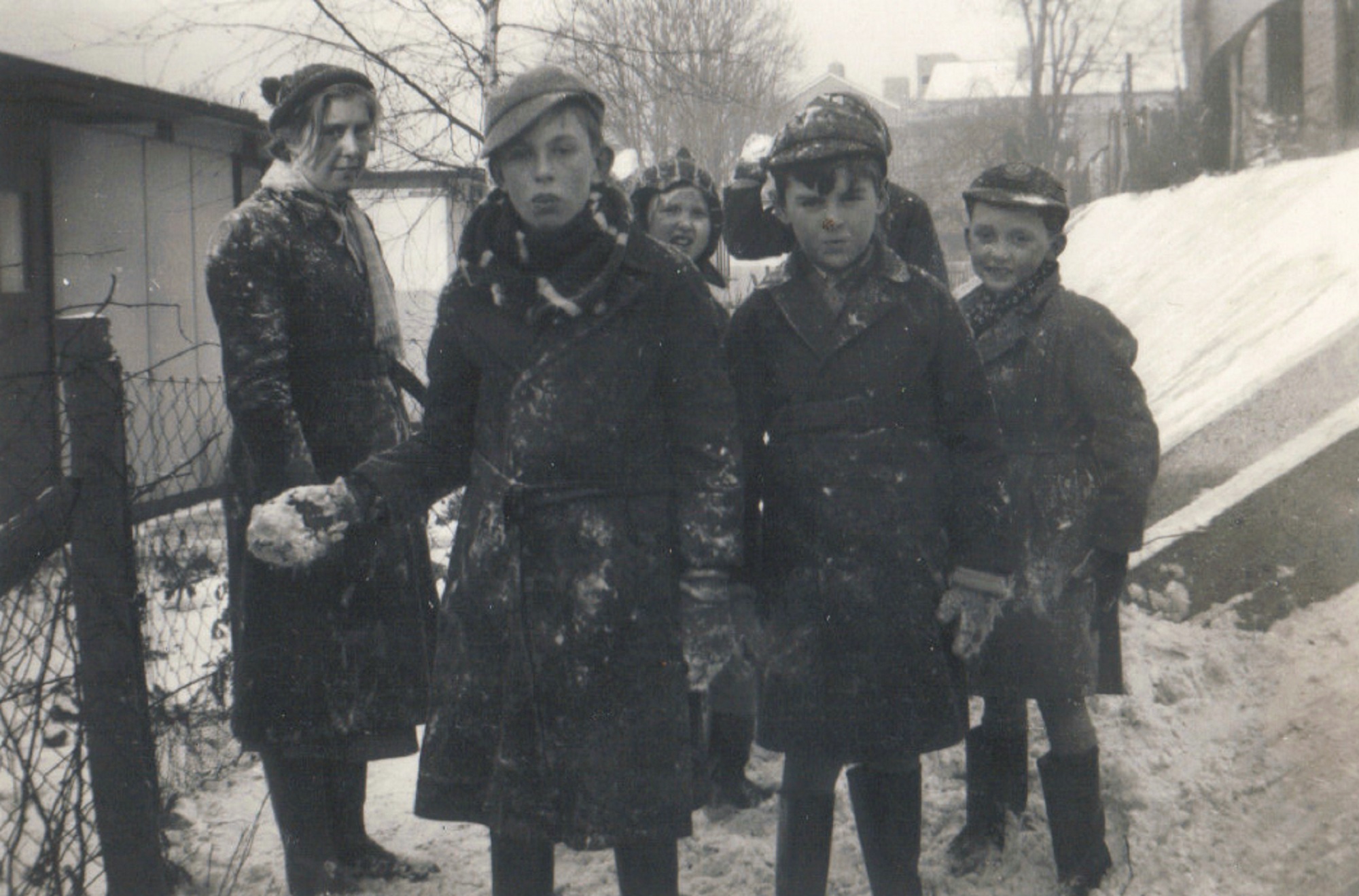 A group outside the prefabs in the snow, Dartmouth Park Hill, London N19