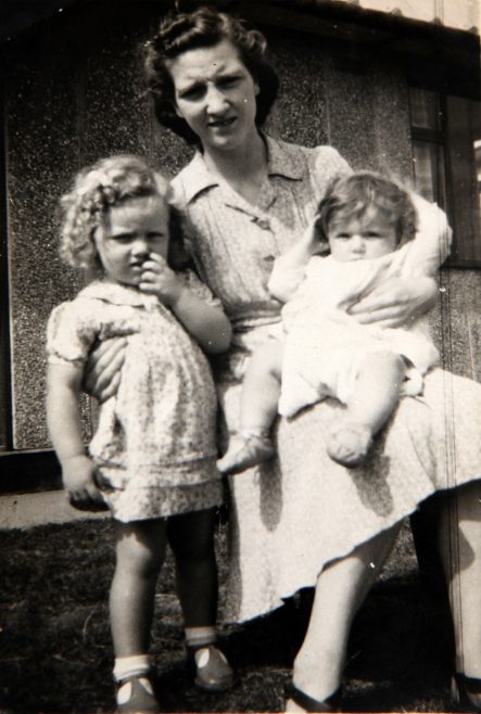 Mum and two children outside Tarran prefab. Bolsover, Derbyshire