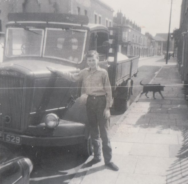 Older brother Harry in Tooke St standing outside our prefab which is out of view to the right. Another prefab(one of four here) is visible through the windscreen of the lorry.