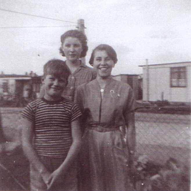 Jim and two girls outside the prefab. Excalibur Estate, London SE6