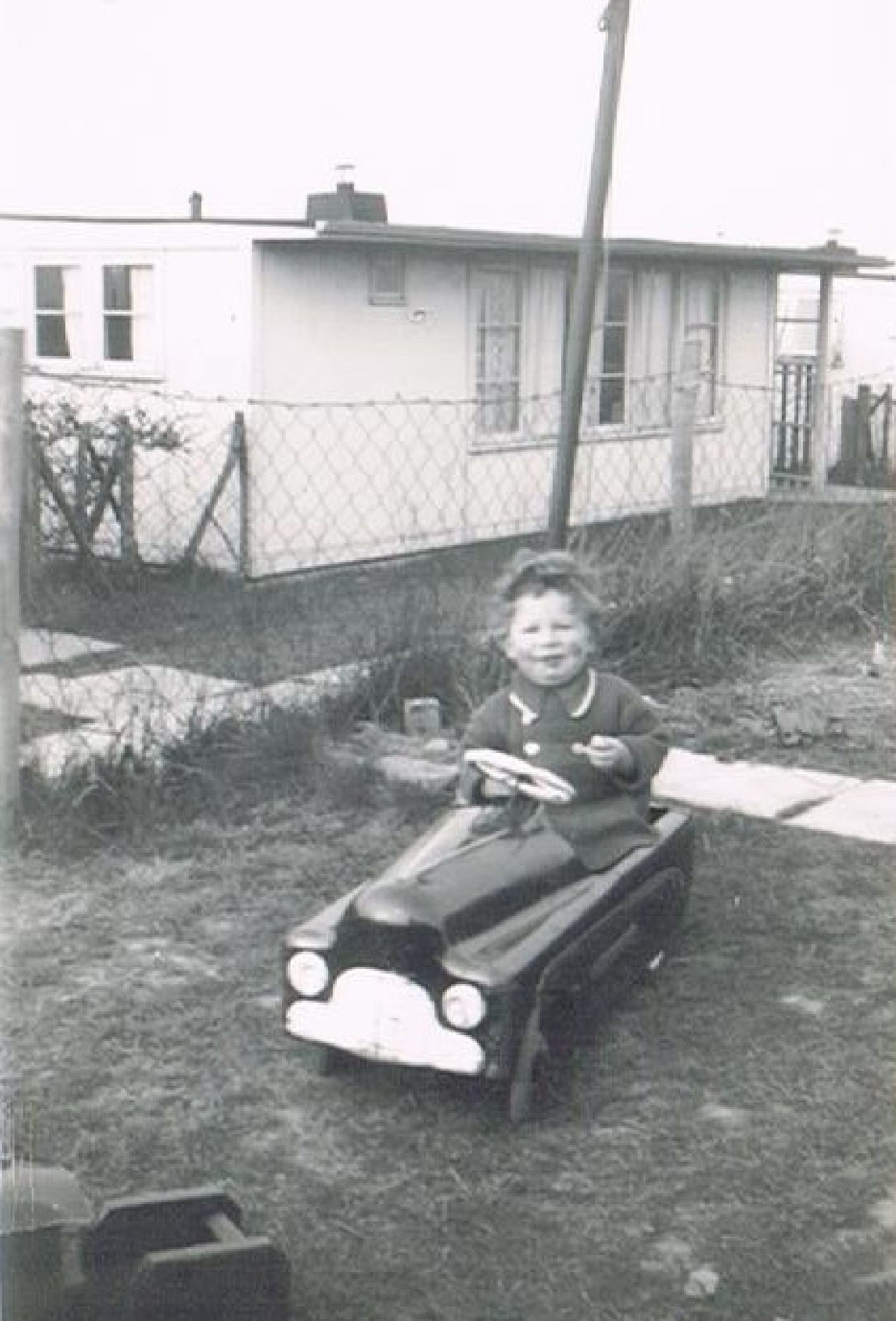 Bernard in his toy car, prefab garden. 60 Harewood Road, Coventry
