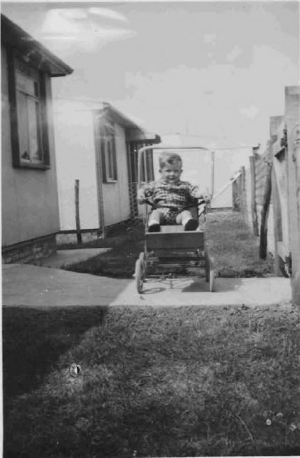 Bob in his pushchair outside the prefabs. Barnfield Road, St Mary Cray