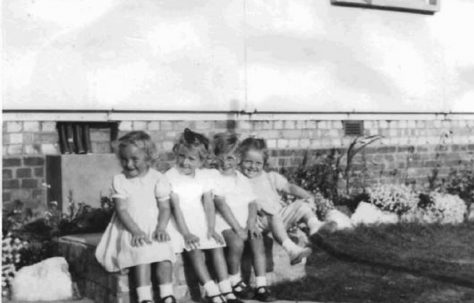 Four toddlers sitting on a wall. Barnfield Road, St Mary Cray