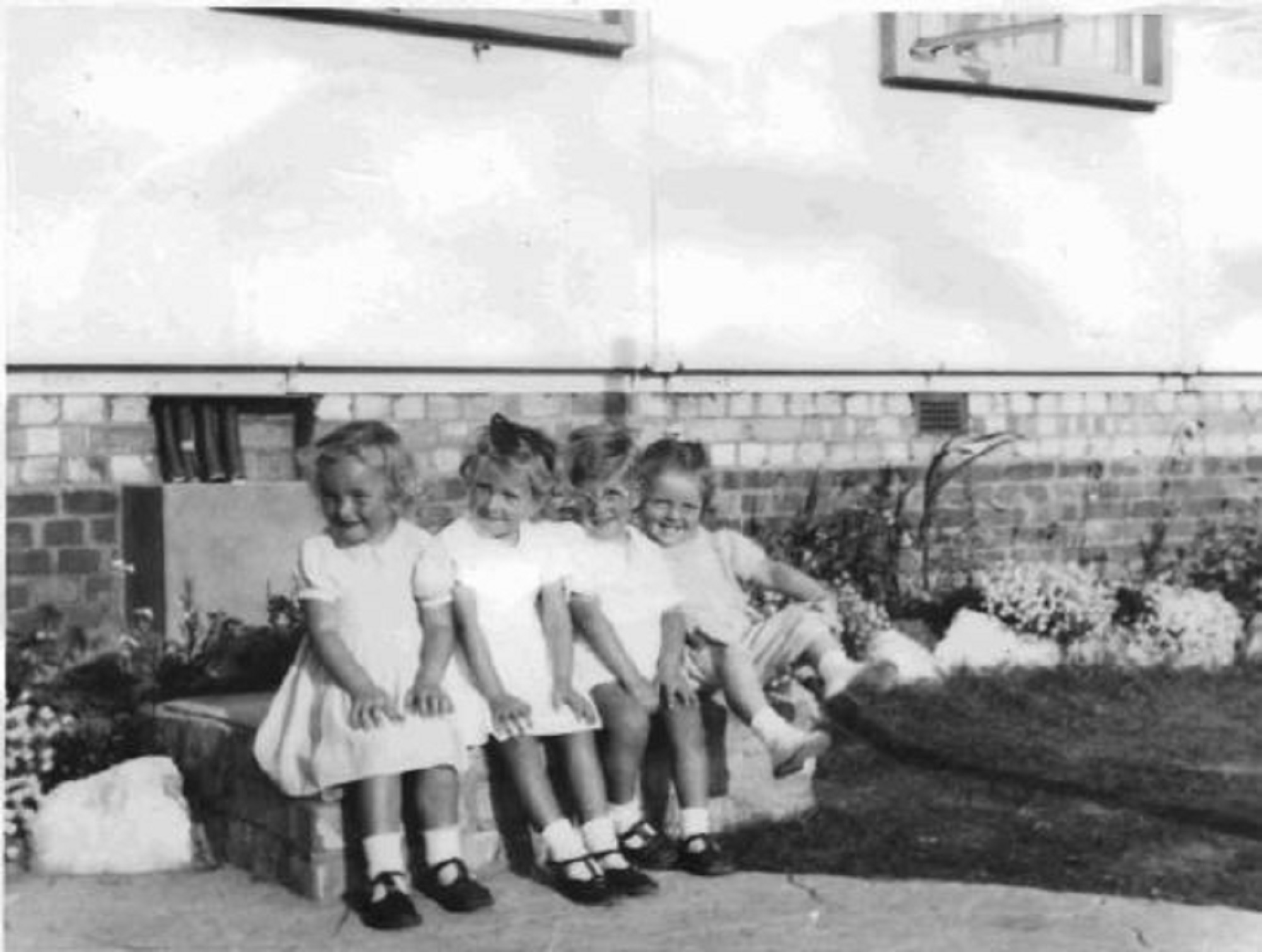 Four toddlers sitting on a wall. Barnfield Road, St Mary Cray