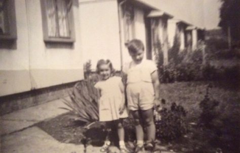 Billy and Angela outside their prefab at 8 Cedar Way, Acton W3