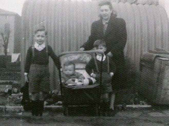 Mum and we three boys, posing outside the Anderson shelter. This would have been in 1948, judging by my physical size in the pram.