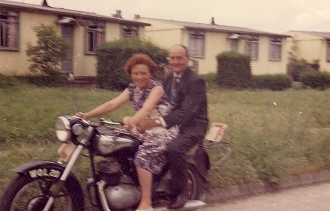 Martyn's grandparents on a motorbike outside the prefabs. Stapleford Road, Kings Norton