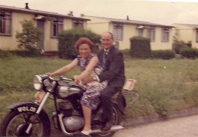 Martyn's grandparents on a motorbike outside the prefabs. Stapleford Road, Kings Norton