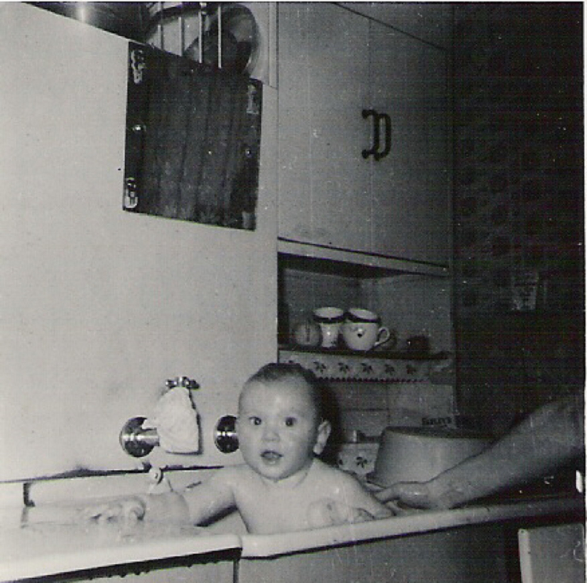 Graham having a baby bath in sink, 849 Ripple Road