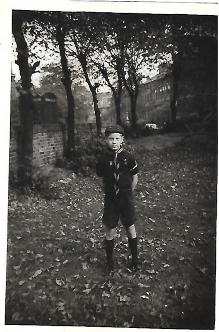 WOLF CUB JOHN BUGG IN GARDEN. MOUND BEHIND IS BURIED DEBRIS OF PREVIOUS BOMBED HOUSES. 1957