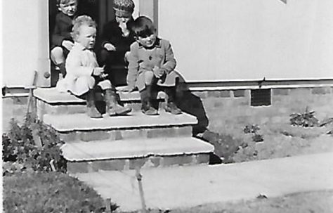 Pat (on the front at the right) and friends on the prefab steps, Douglas Road, Lenham