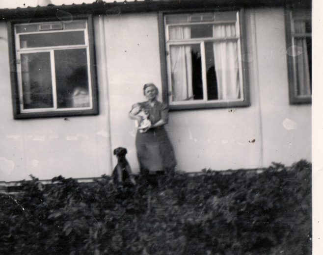 Winifred Arnold holding a baby (Roy Woollard) and a dog, plus dog sitting. 13 Mill Close, Ringmer | Kevin Arnold